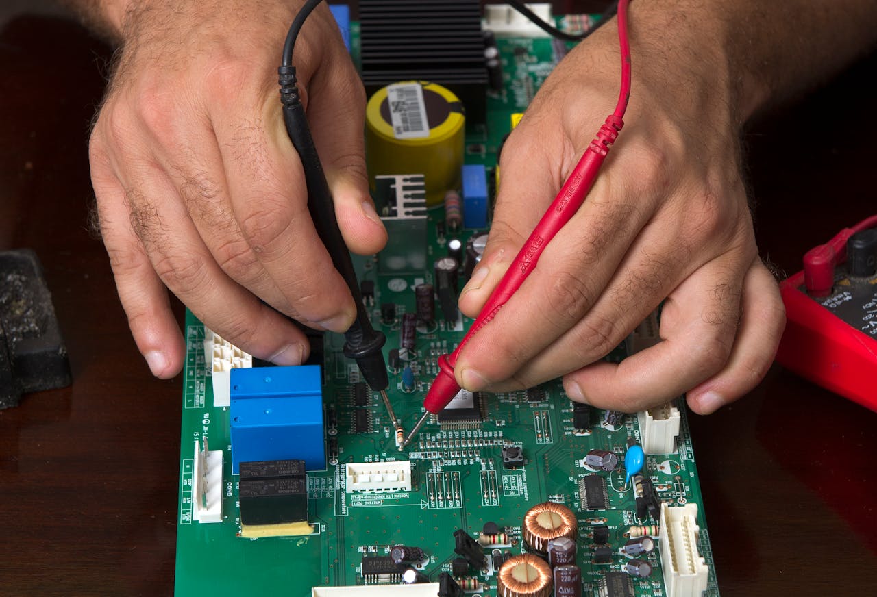 A detailed view of hands working on a circuit board using probes, depicting precision and electronics repair.